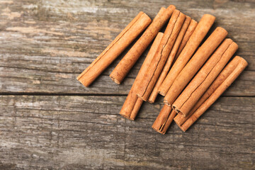 Cinnamon sticks on a textured wooden background. Cinnamon roll. Spicy spice for baking, desserts and drinks. Fragrant ground cinnamon. cinnamon powder Close-up. Place for text. copy space