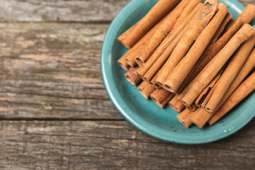 Cinnamon sticks on a textured wooden background. Cinnamon roll. Spicy spice for baking, desserts and drinks. Fragrant ground cinnamon. cinnamon powder Close-up. Place for text. copy space