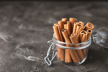 Cinnamon sticks on a textured wooden background. Cinnamon roll. Spicy spice for baking, desserts and drinks. Fragrant ground cinnamon. cinnamon powder Close-up. Place for text. copy space