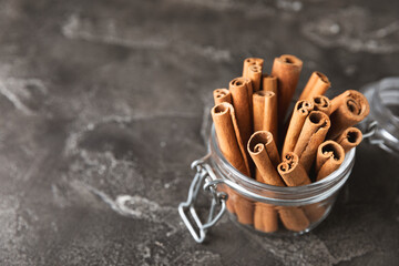 Cinnamon sticks on a textured wooden background. Cinnamon roll. Spicy spice for baking, desserts and drinks. Fragrant ground cinnamon. cinnamon powder Close-up. Place for text. copy space