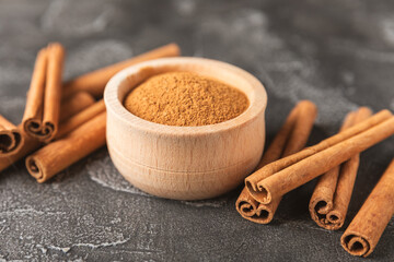 Cinnamon sticks on a textured wooden background. Cinnamon roll. Spicy spice for baking, desserts and drinks. Fragrant ground cinnamon. cinnamon powder Close-up. Place for text. copy space