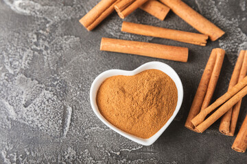 Cinnamon sticks on a textured wooden background. Cinnamon roll. Spicy spice for baking, desserts and drinks. Fragrant ground cinnamon. cinnamon powder Close-up. Place for text. copy space