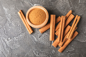 Cinnamon sticks on a textured wooden background. Cinnamon roll. Spicy spice for baking, desserts and drinks. Fragrant ground cinnamon. cinnamon powder Close-up. Place for text. copy space