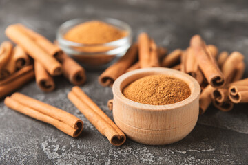 Cinnamon sticks on a textured wooden background. Cinnamon roll. Spicy spice for baking, desserts and drinks. Fragrant ground cinnamon. cinnamon powder Close-up. Place for text. copy space