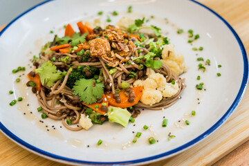 Japanese buckwheat pasta with lentils and vegetables in a bowl