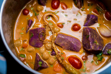 Chef at the kitchen preparing massaman curry with sweet potato and many spices