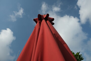 red folded umbrella against sky