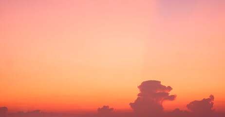 Sunset sky background in the evening with colorful yellow orange sunlight and row of cloud on...