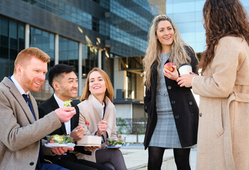 Group of international businesspeople having lunch at city street outside of the office.