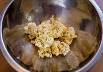 Chef at the kitchen preparing bean porridge with cauliflower and vegetables