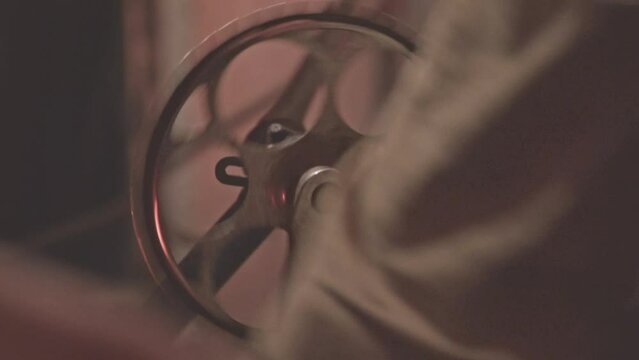 Close up of dynamo machine for generating electricity. Footage. Spinning mechanism by hands.