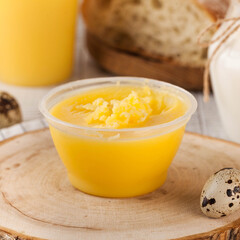 Melted butter in a plastic cup made from farm milk. Dairy products