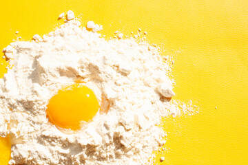 Yolk in flour on a yellow background. homemade baking. Top of view