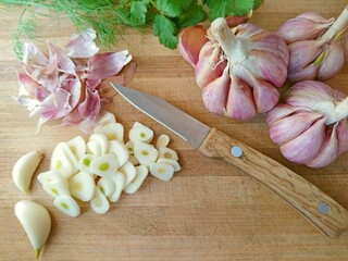 Garlic sliced & red garlic bulb, cloves on wooden background. Concept healthy organic purple cut...
