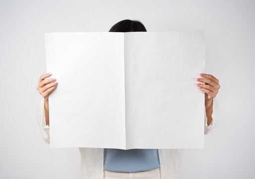 Woman reading mockup of blank newspapers to add your own news isolated on white background.