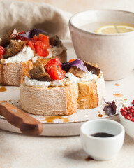 Delicious bruschetta topped with soft cheese, fresh tomato slices, and roasted eggplant. 