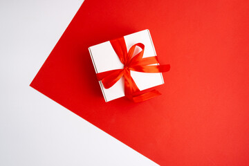 Gift box with a bow on a colored background. Happy Holidays, gift box close-up. Boxing Day surprise. Magic time. Wrapping paper, toys and ribbon