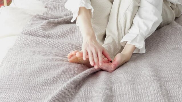 冷えた足を擦る女性