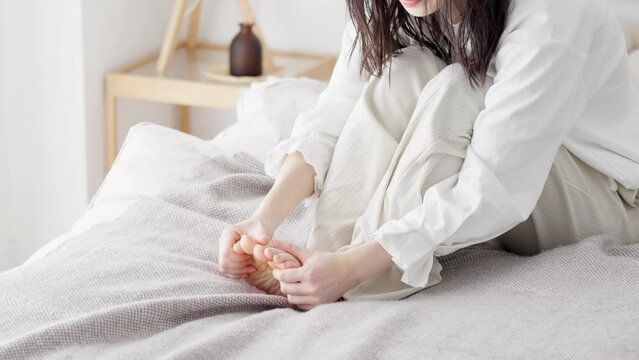 冷えた足を擦る女性