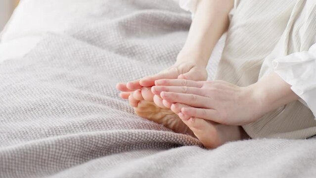 冷えた足を擦る女性