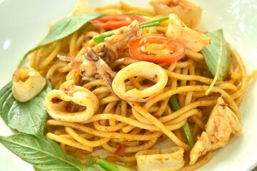 spicy stir fried spaghetti slice squid with chili and basil leaf in sauce on plate 