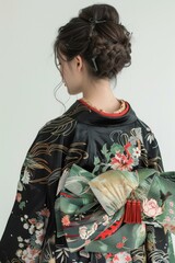 Fototapeta premium A woman wearing a kimono with a floral pattern and a green obi