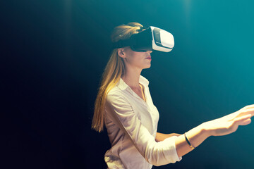 A woman is playing a video game with a virtual reality headset. Business woman wearing virtual...