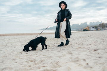 Young woman with her dog on leash walking