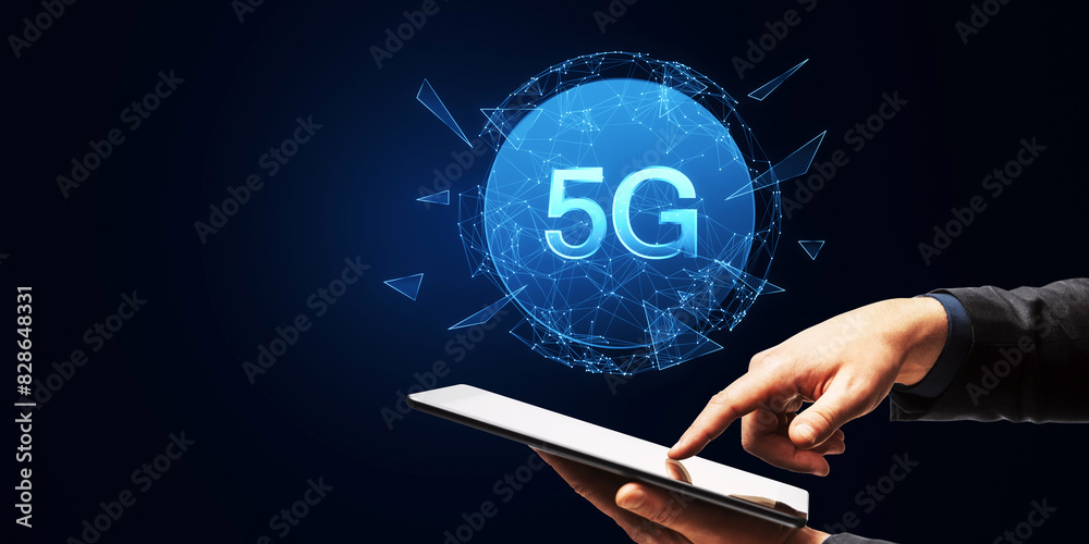 Poster hand holding a tablet with a glowing 5g network hologram emanating from the screen on a dark blue ba