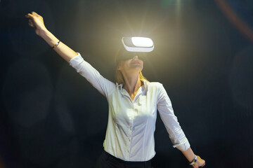 A woman is playing a video game with a virtual reality headset. Business woman wearing virtual...