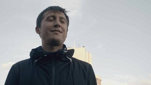 Man commits suicide from roof. Stock. Cinematic shot of actor playing suicide scene on rooftop. Man smiles and falls back from roof of building