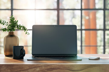 Laptop with a blank screen on a wooden table, vase with a plant and a mug besides it, light background through large windows, concept of a workspace. 3D Rendering