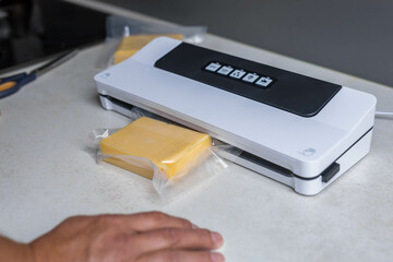 man vacuum-packing cheese with a vacuum cleaner