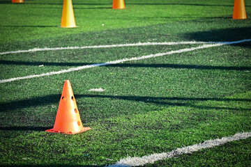 artificial green grass soccer field with orange training cones