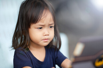 Cute Asian sibling girl sitting Uses the tablet