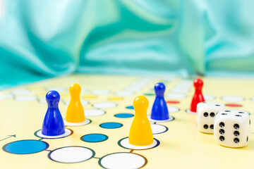 ludo game close up with pawns dices and blue background, soft focus close up
