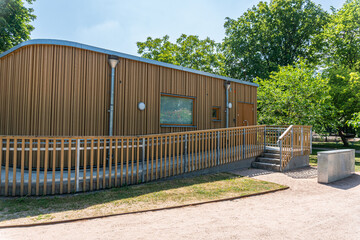 A stylish, modern, single-story wooden building with an inclusive entrance