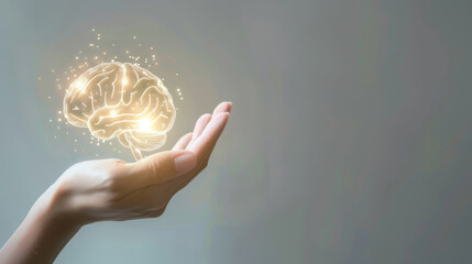 Digital composite of a luminescent brain floating above a person's open palm