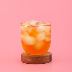 Glass of Apple spritzer or Apfelschorle drink on pink background. Cold carbonated apple juice. Homemade spritzer served with ice. Side view