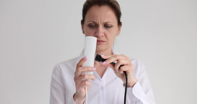 American plug with cable will not fit European extension cord. Woman cannot plug American plug into electrical outlet