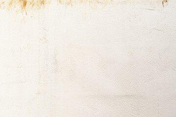 Dirty old uneven render concrete wall with red soil stains. Grunge and rough surface. 