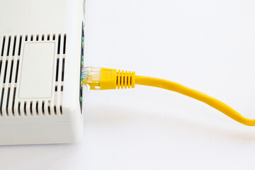 ADSL modem with yellow cable on white surface with copy space