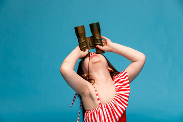 Little girl, kid Sailor, ship captain in Striped red swimsuit with binoculars and steering wheel on...