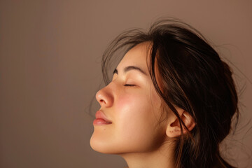 Fototapeta premium A close up of a woman's face with her eyes closed looking to a side