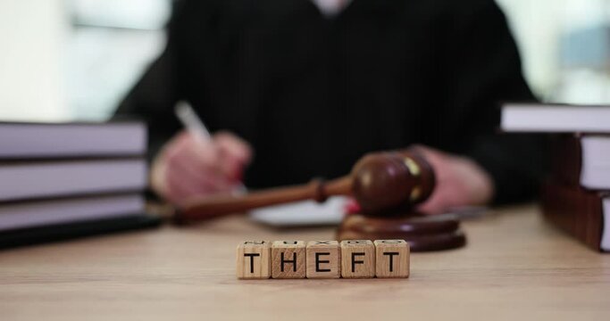 Word theft on judge table and judge gavel closeup. Thefts and examples from investigative practice