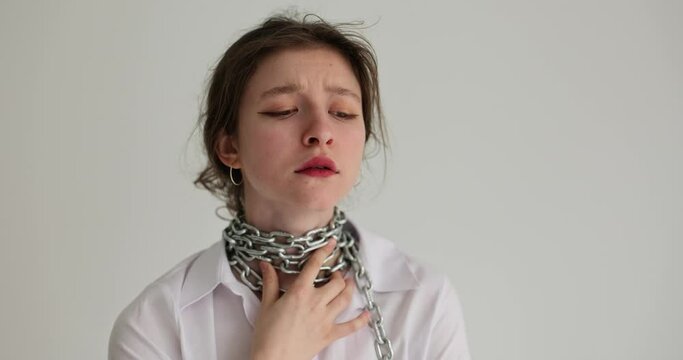 Portrait of woman touches chain around neck. Heaviness and sore throat or choking