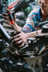 Obraz premium A motorcycle mechanic inspecting a damaged engine