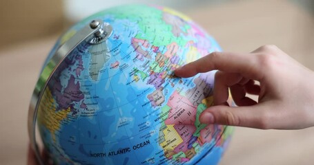 Hand touching globe globe search country on map. Tourist is planning trip to Europe