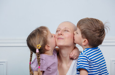Woman struggling with cancer kissed by her two loving children