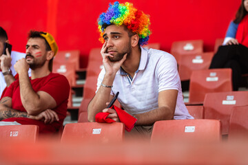 Disappointed sport fan watching a game in the stadium, this team is losing